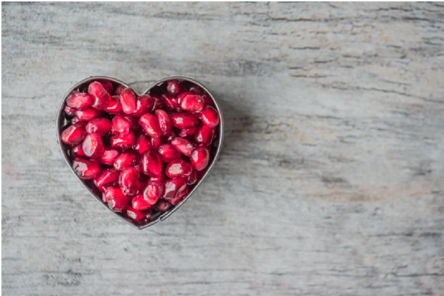 A heart-shaped container with heart-healthy pomegranates.